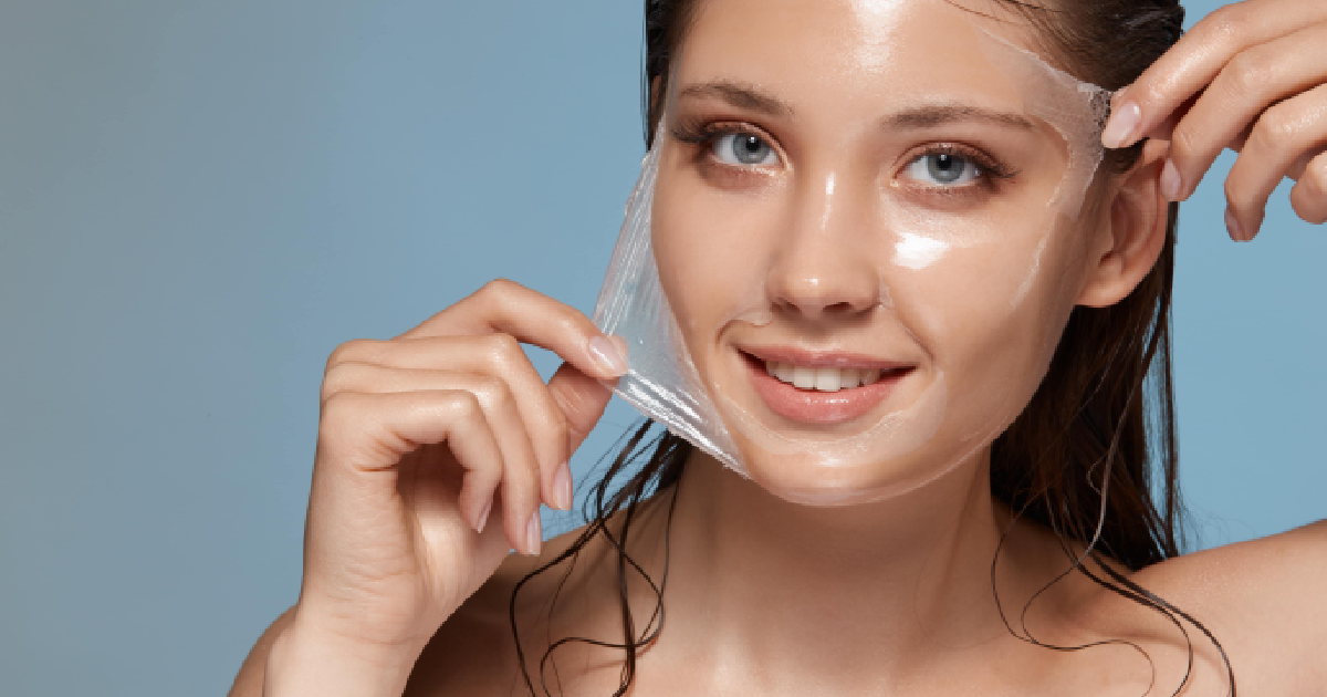 Smiling woman peeling off clear facial mask after Chemical Peels in Houston, TX
