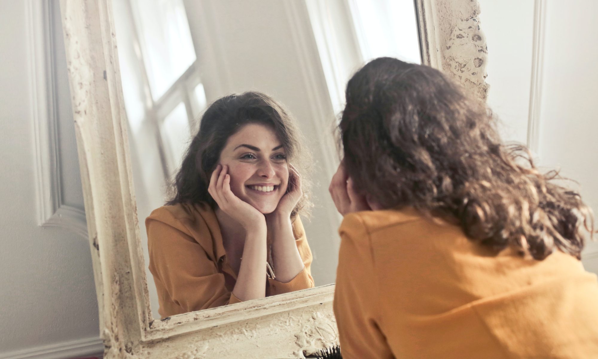 Woman Smiling and Looking at the Mirror